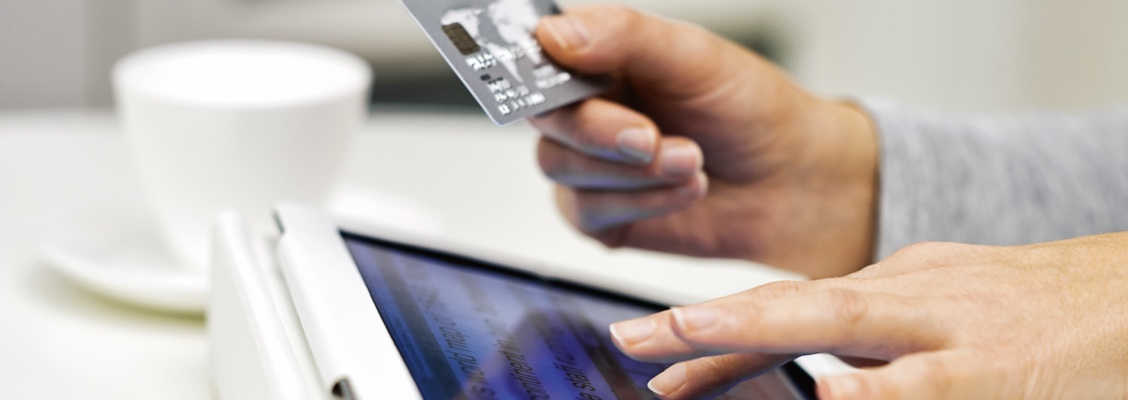 Person entering credit card details to make payment on a tablet